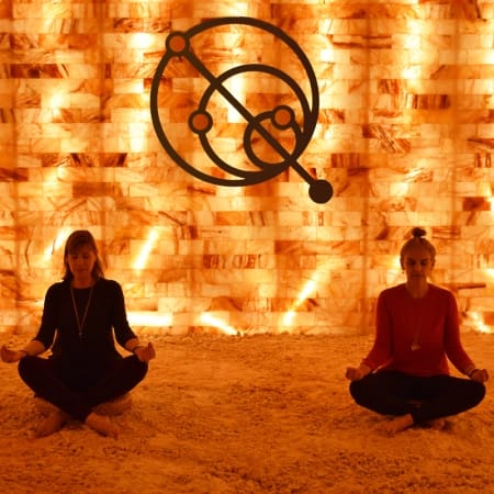 People meditating next to the salt wall at Quasar Quantum Healing
